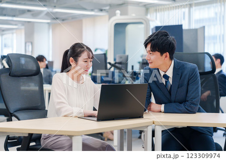 先輩社員から業務を教えてもらう新人の女性 123309974