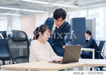 先輩社員から業務を教えてもらう新人の女性 先輩社員から業務を教えてもらう新人の女性 123310002