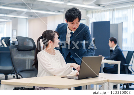 先輩社員から業務を教えてもらう新人の女性 先輩社員から業務を教えてもらう新人の女性 123310008