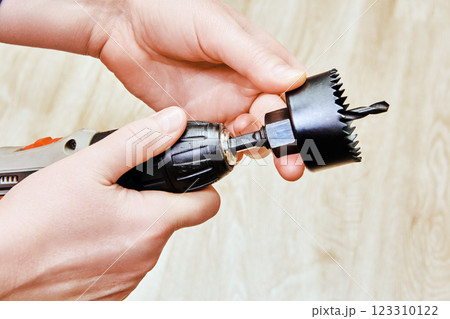 Cordless screwdriver and hole saw, equipped with drill bit, facilitate clean and accurate hole creation for door locks. 123310122