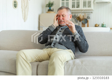 Headache pain. Unhappy middle aged senior man suffering from headache sick rubbing temples at home. Mature old senior grandfather touching temples experiencing stress. Man feeling pain hurt in head Headache pain. Unhappy middle aged senior man suffering from headache sick rubbing temples at home. Mature old senior grandfather touching temples experiencing stress. Man feeling pain hurt in head 123310183