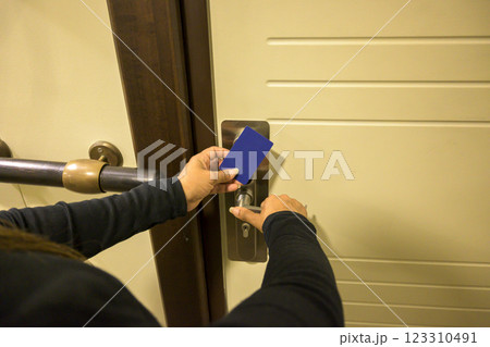 Hand using a keycard to unlock a door lock indoors, key electronic lock, hotel room, holidays in mallorca, spain Hand using a keycard to unlock a door lock indoors, key electronic lock, hotel room, holidays in mallorca, spain 123310491