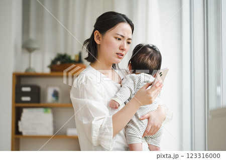 赤ちゃんの具合が悪くてスマホで検索する女性 123316000