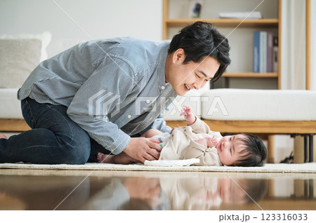 赤ちゃんのおむつを取り替えるパパ 123316033