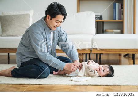 赤ちゃんのおむつを取り替えるパパ 123316035