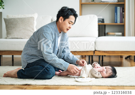 赤ちゃんのおむつを取り替えるパパ 123316038