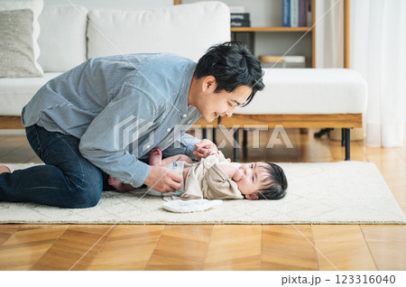 赤ちゃんのおむつを取り替えるパパ 123316040