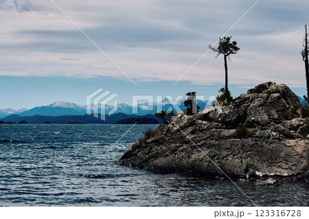 A huge boulder on the shore of a blue lake. 123316728