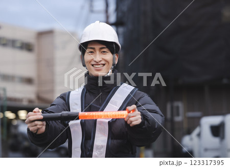 交通誘導をする若い男性 123317395