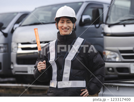 交通誘導をする若い男性 123317400