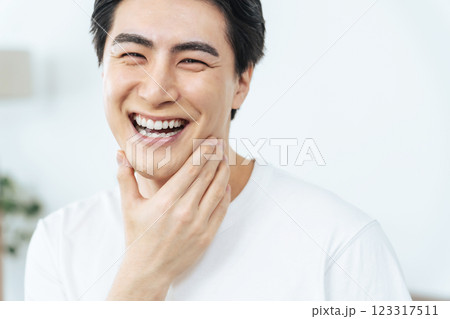 白い歯を見せて笑う青年男性 白い歯を見せて笑う青年男性 123317511