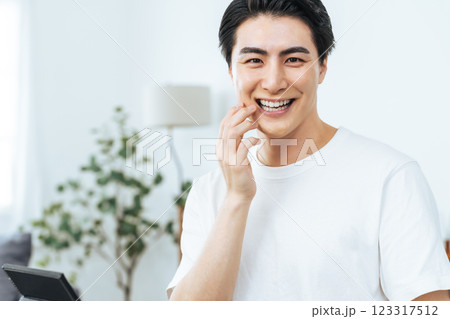 白い歯を見せて笑う青年男性 白い歯を見せて笑う青年男性 123317512