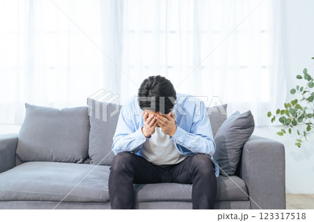 部屋で落ち込む男性 123317518