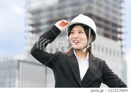 スーツにヘルメットを工事現場に立つ若い女性 施工管理者 現場監督 土木女子(ドボジョ) スーツにヘルメットを工事現場に立つ若い女性 施工管理者 現場監督 土木女子(ドボジョ) 123317604