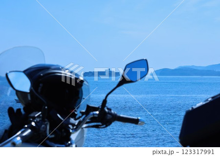 バイクで旅に出たら、海に浮かぶ貨物船を見つめていた 123317991