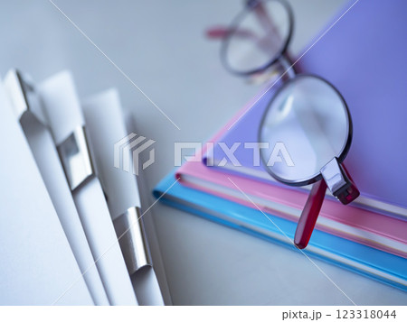 テーブルに置かれた書類と手帳とメガネ 123318044