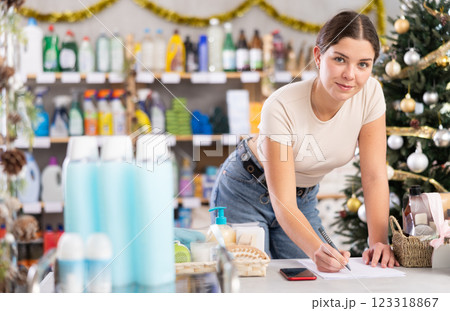 Female businessperson with paper document, plans to replenish restock stores inventory on Christmas Eve Female businessperson with paper document, plans to replenish restock stores inventory on Christmas Eve 123318867