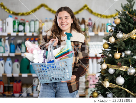 Woman buyer with filled basket household chemistry wanders around store Woman buyer with filled basket household chemistry wanders around store 123318898
