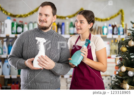 Smiling saleswoman offering cleaning sprays to shopper in home care store 123318905