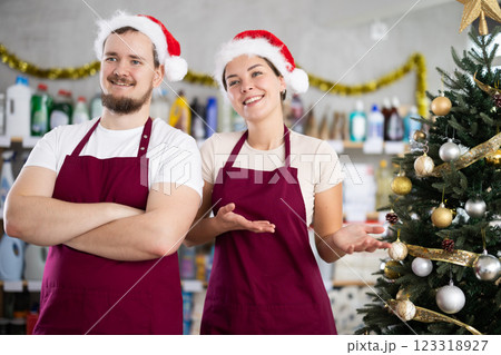 Friendly sellers in Santa hats inviting to household goods store 123318927