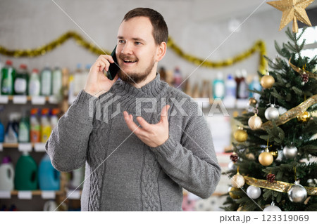 Man talks on his mobile phone while shopping in supermarket 123319069