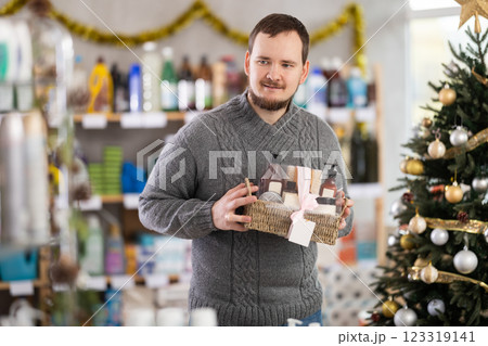Interested nice bearded man choosing gifts for New Year in household department of supermarket Interested nice bearded man choosing gifts for New Year in household department of supermarket 123319141