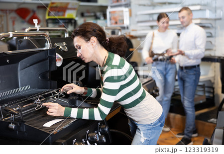 Woman looking at new bbq grill in showroom Woman looking at new bbq grill in showroom 123319319