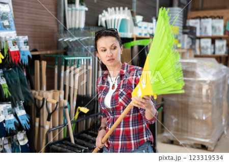 Woman shopping at hardware store - choosing broom 123319534