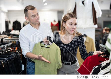 Man with wife participate in inspection of goods, help determine choice of dress Man with wife participate in inspection of goods, help determine choice of dress 123319567
