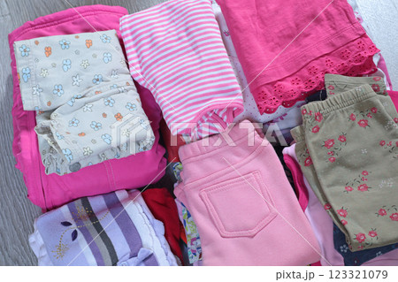 Stack of baby clothes in pink and postel colors. Cleaning and recycling. Ecology and upcycle. 123321079