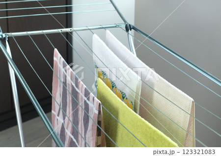 Wet bath towels and flannel linens hanging and drying on rack dryer. Cleanliness and Housekeeping. Caring for home and order. Wet bath towels and flannel linens hanging and drying on rack dryer. Cleanliness and Housekeeping. Caring for home and order. 123321083