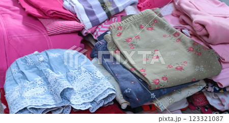 Stack of baby clothes in pink and postel colors. Cleaning and recycling. Ecology and upcycle. 123321087