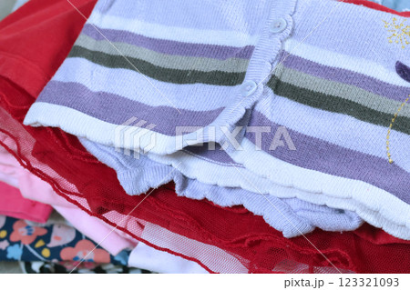 Stack of baby clothes in pink and postel colors. Cleaning and recycling. Ecology and upcycle. 123321093