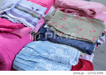 Stack of baby clothes in pink and postel colors. Cleaning and recycling. Ecology and upcycle. 123321094