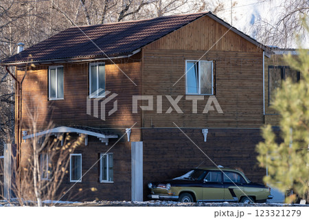 Wooden two storey house with a parked retro car. 123321279