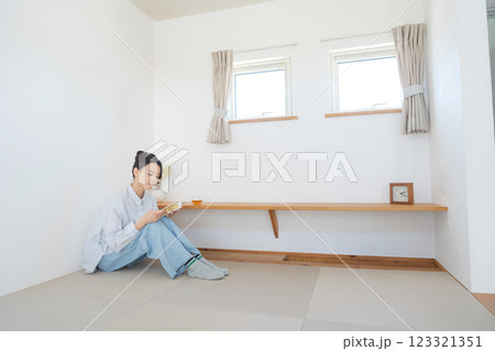畳の小上がりでくつろぐ女性 畳の小上がりでくつろぐ女性 123321351