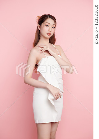 Beautiful face of young Asian woman in sexy dress white Perfect slim body on pink background, plastic surgery and aesthetic cosmetology, Facial and skin care concept 123321610