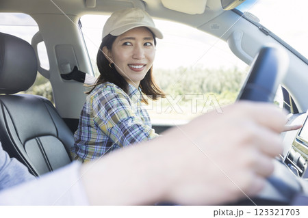 ドライブに行く前にどこに行き先を設定するか話す男女 123321703