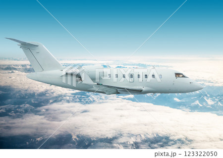 White modern executive jetliner flies over snow-covered mountains 123322050