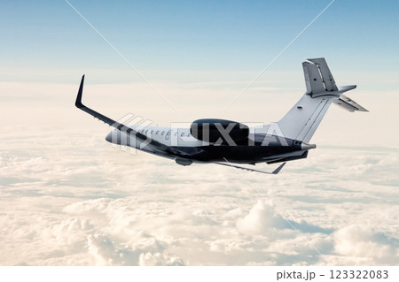 Modern luxury business jet flies in the air above the clouds 123322083