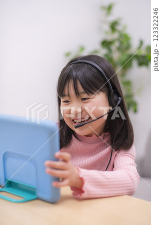 ヘッドセットをつけてパソコンでオンライン学習をする小学生の女の子 123322246