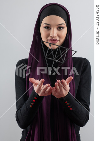 Elegant Muslim woman in a hijab with a geometric structure in a conceptual portrait. 123324550