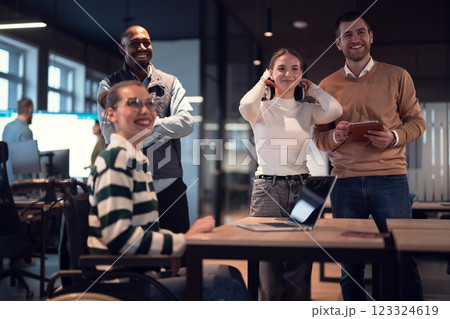 Disabled businesswoman in a wheelchair working in modern coworking office. Team around is using virtual reality goggles, collaborating with the latest technology in an open space startup creative 123324619