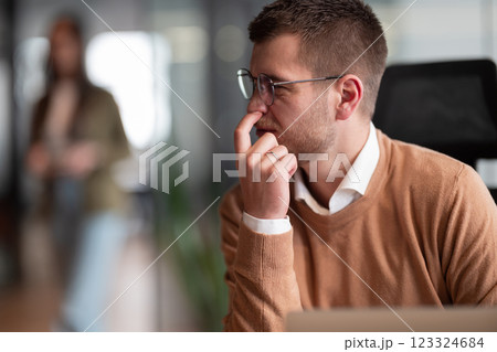 Funny scene of a businessman putting a finger in his nose. Employee in the office, thinking and brainstorming ideas for a startup. Man at workplace working on laptop, copywriting and innovation in a Funny scene of a businessman putting a finger in his nose. Employee in the office, thinking and brainstorming ideas for a startup. Man at workplace working on laptop, copywriting and innovation in a 123324684