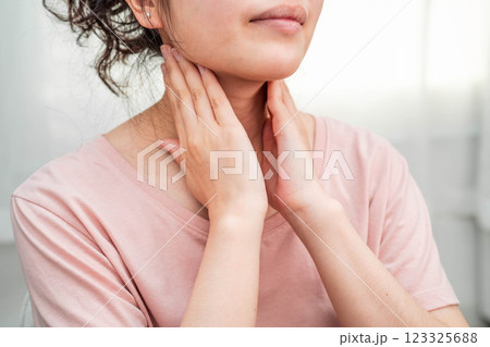 Asian woman touching her neck and throat for thyroid gland problem. Asian woman touching her neck and throat for thyroid gland problem. 123325688