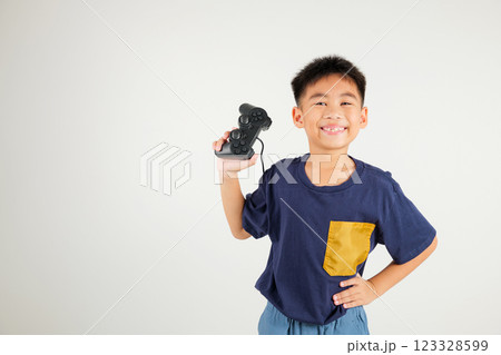 Asian happy portrait young kid boy smile lifestyle games technology holding joystick game playing on hands studio shot isolated on white background with copy space, primary children relaxation time 123328599