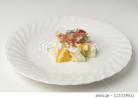 白い大皿に盛り付けた生ハムと大根のサラダ 123329632