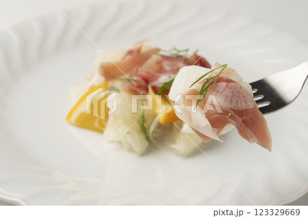 白い大皿に盛り付けた生ハムと大根のサラダ 123329669