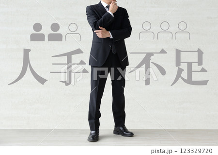 人手不足に悩むスーツを着た男性のイメージ画像 123329720