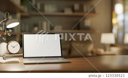 The white screen laptop on wooden table with decorative item in dim light study room or living room. 123330521
